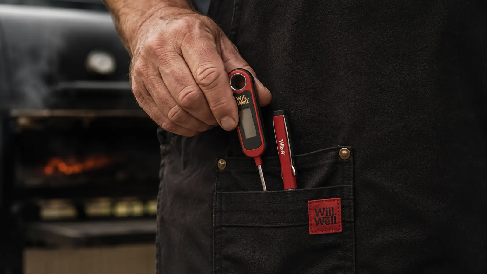 Close-up of a hand pulling an instant-read thermometer and a pen out of a black apron's front pocket